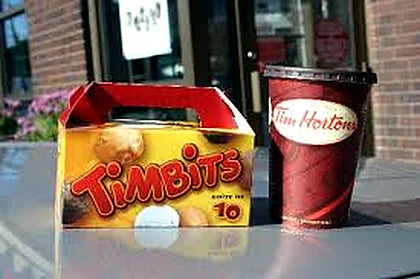 Timbits box and Tim Hortons cup on an outdoor table